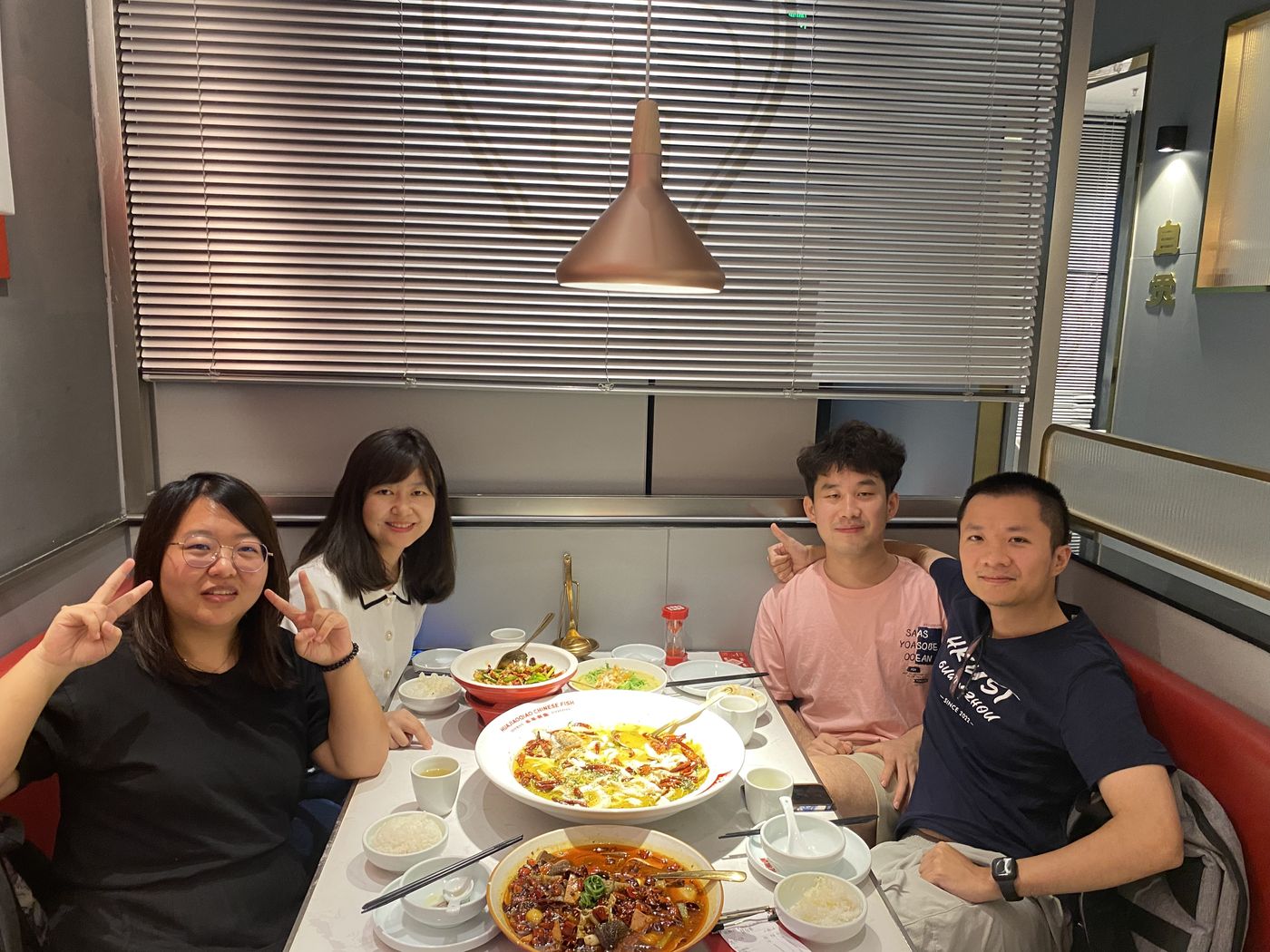 Four lab members at a restaurant table full of dishes