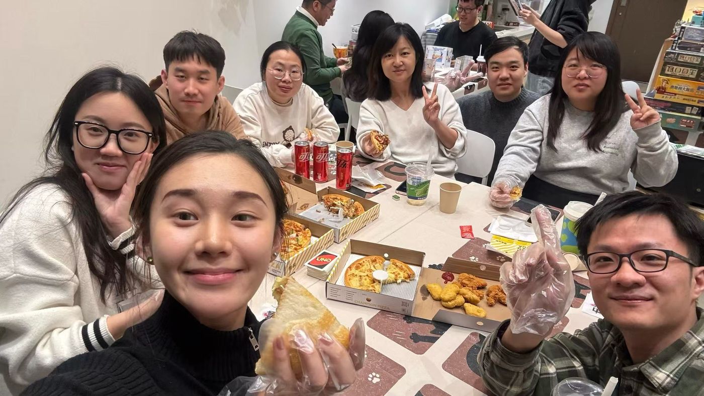 Lab members around a table of pizza boxes in the lab